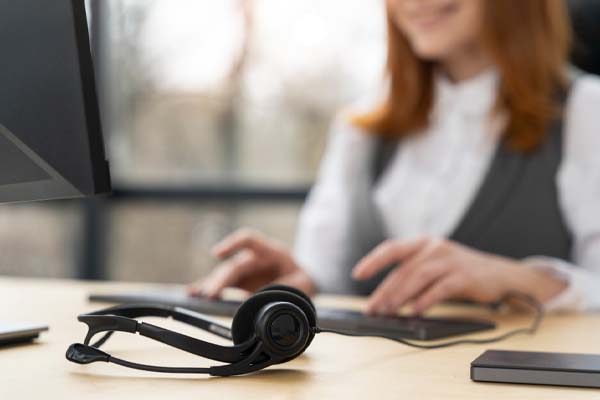 Casque micro sur une table de travail indiquant une assistance disponible